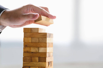 商人安排木块叠加塔手业务组织公司增长进步成功策略钱投资概念风险管理项目主题