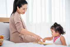 亚洲妈妈。教学女孩女儿阅读书房子检疫首页概念快乐家庭主题