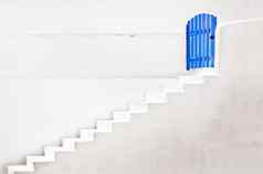 概念蓝色的通过白色墙楼梯通过概念门楼梯