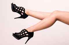 长腿长腿的女人穿黑色的时尚高高跟鞋凉鞋