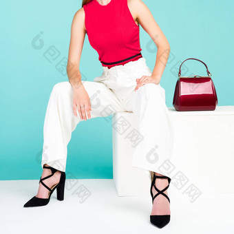 美丽的女人坐着板凳上手提包钱包高非常鞋子