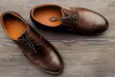 时尚男人的经典棕色（的）鞋子木背景