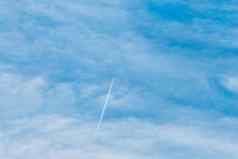 跟踪飞行飞机蓝色的天空软白色毛茸茸的云背景