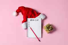 一年圣诞节列表概念记事本圣诞老人老人他礼物盒子孤立的粉红色的背景假期横幅复制空间