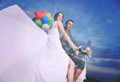 结婚了夫妇海滩骑白色踏板车