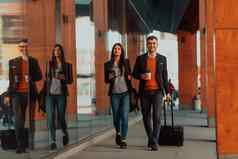业务男人。业务女人会说话的持有行李旅行业务旅行携带新鲜的咖啡手业务概念