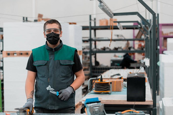 重行业工程工厂室内工业工人角磨床切割金属管穿面具脸冠状病毒流感大流行