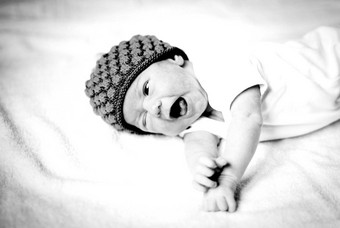 可爱的新生儿婴儿无檐小便帽说谎床上黑色的白色照片