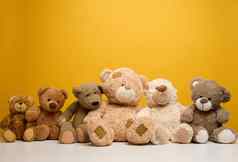 集团可爱的棕色（的）泰迪熊坐黄色的背景儿童玩具