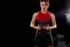 运动适合女人运动员哑铃使健身练习黑色的背景