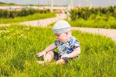 可爱的蹒跚学步的婴儿男孩孩子玩公园草一天时间有趣的花园