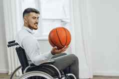 禁用年轻的男人。轮椅持有篮球球