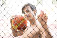 十几岁的男孩城市操场上持有篮球球