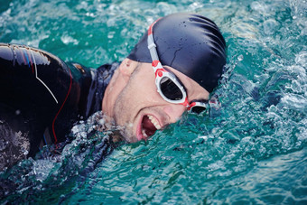 三项全能运动运动员游泳湖日出穿潜水服