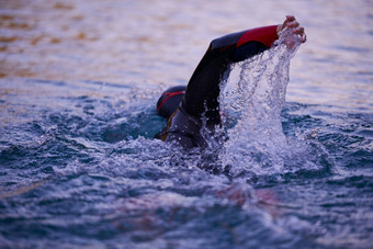 三项全能运动运动员游泳湖日出穿潜水服