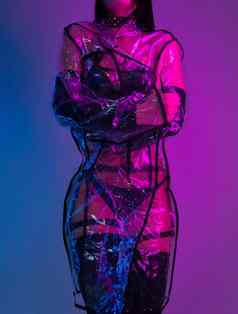 纤细的女人泳衣透明的雨衣霓虹灯光