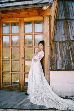 新娘白色花边衣服玻璃通过木小屋