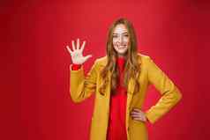 女孩给星星太棒了互联网商店买了装秋天天气显示提高了棕榈微笑广泛的站时尚的温暖的黄色的外套红色的背景