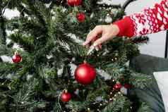 快乐年轻的女人装修圣诞节树