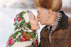 肖像快乐高级夫妇上了年纪的女人吻丈夫有分量的夫妇走公园冬天时间快乐家庭黄金婚礼