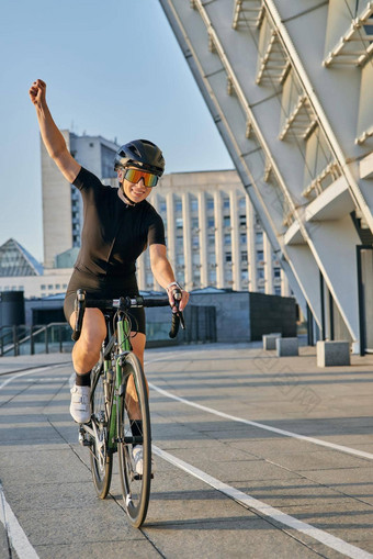 兴奋专业女骑自行车的人<strong>黑色</strong>的骑自行车服装保护齿轮微笑提高手臂满意结果培训