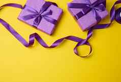 包装盒子礼物紫色的纸丝绸丝带黄色的背景前视图祝贺你惊喜