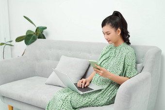 亚洲女孩移动PC智能手机坐着沙发舒适的首页interiorasian女孩移动PC智能手机坐着沙发舒适的首页室内