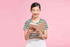 有吸引力的亚洲女人阅读书粉红色的背景