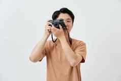 年轻的亚洲男人。采取照片相机旅行白色背景