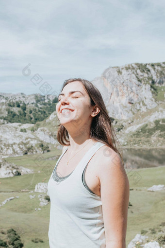 肖像年轻的微笑女人脸多风的一天站山无忧无虑的女人快乐旅行者赶时髦的人女孩多风的头发微笑前山空间文本大气时刻