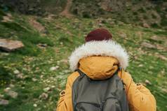 女人黄色的夹克徒步旅行山旅行冒险