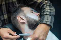 年轻的有胡子的男人。剃理发师理发店