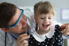 男人。儿科医生检查女孩健康条件特殊的工具口