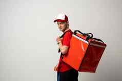 年轻的快递红色的统一的t恤红色的食物热袋肩膀站孤立的白色背景工作室食物交付服务