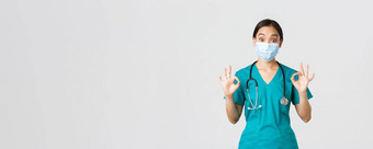 科维德冠状病毒疾病医疗保健工人概念兴奋深刻的印象亚洲女医生实习生医疗面具实习医生风云显示手势批准白色背景