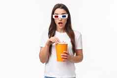 娱乐有趣的假期概念肖像喘气惊讶吓了一跳年轻的女人看有趣的激动电影享受很酷的电影吃爆米花穿眼镜