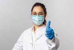 医生infectionist研究科维德概念自信年轻的快乐亚洲女医生显示翘拇指鼓励人保持内部战斗疾病病毒穿脸面具手套