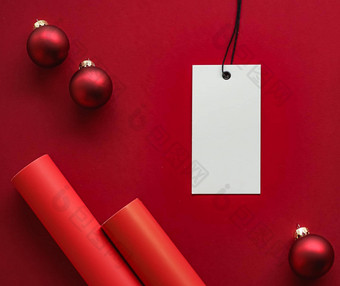 圣诞节出售假期时尚设计概念空白<strong>服装</strong>标签圣诞节装饰<strong>饰品</strong>红色的纸背景平铺模型