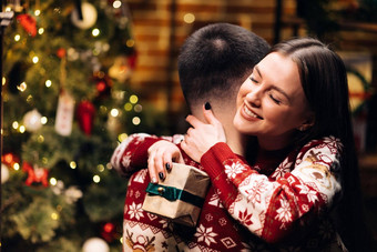 快乐女人拥抱的男朋友拥抱装饰发光的冷杉树浪漫的冬天故事快乐妻子感觉感激的拥抱丈夫表达感激之情一年礼物