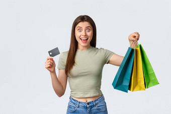 购物购物中心生活方式时尚概念兴奋好看的女人购买衣服夏天服装显示信贷卡袋货物微笑惊讶