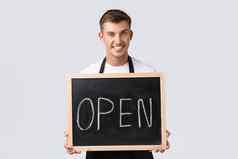 小零售业务主人咖啡馆餐厅员工概念有魅力的微笑服务员推销员持有开放标志欢迎客人站白色背景