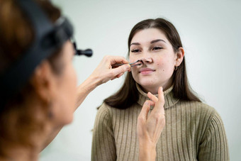 女ent医生检查病人的鼻窦医疗仪器现代诊所检查病人的女孩的鼻子疾病过敏曲率鼻隔