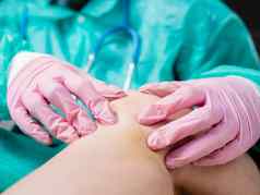 traumatologist触摸受伤的膝盖创伤援助概念