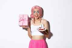 肖像惊讶美丽的女孩粉红色的假发收到生日礼物持有生日蛋糕微笑快乐站白色背景