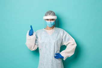 概念科维德流感大流行健康自信女医生佩普脸盾医疗面具显示竖起大拇指保证安全站蓝色的背景