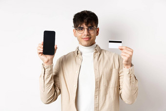 在线购物年轻的现代的家伙显示塑料信贷卡空智能手机屏幕演示账户站白色背景