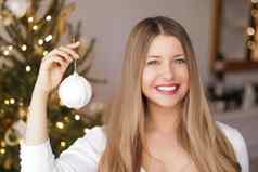 圣诞节装饰假期情绪概念快乐微笑女人装修圣诞节树节日玩具饰品首页