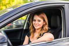 微笑年轻的漂亮的女人黑色的车概念旅行租金车购买车