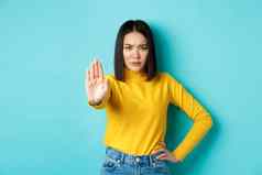 自信亚洲女人显示停止手势禁止警告不同意站心烦意乱蓝色的背景