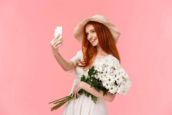 庆祝活动社会媒体互联网概念诱人的时髦的红色头发的人女稻草他春天衣服持有花束采取自拍智能手机白色花微笑很高兴